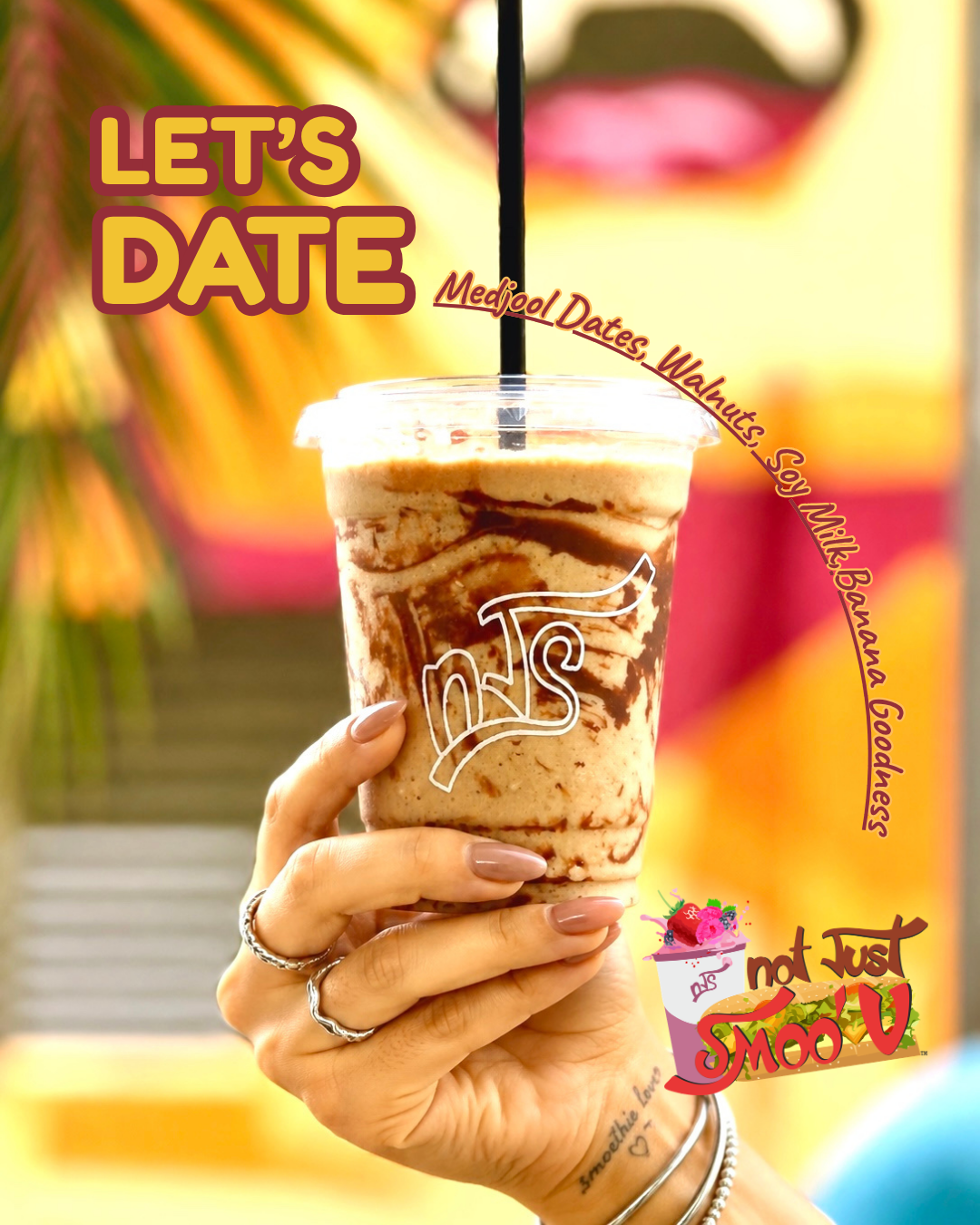Let's Date smoothie held up in front of the Not Just Smoo'V mural wall
