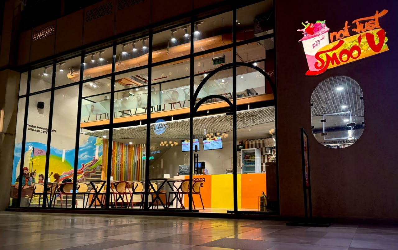 Not Just Smoo'V storefront lit up at night, AIPL Joy Central, Gurugram